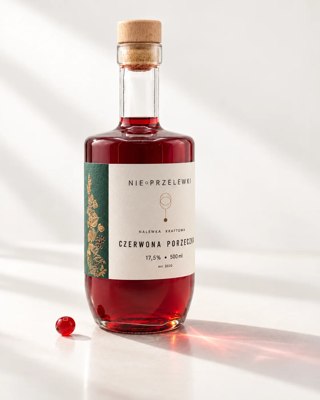 A 500 ml bottle of Redcurrant from the side, the colour of the liquid against the light