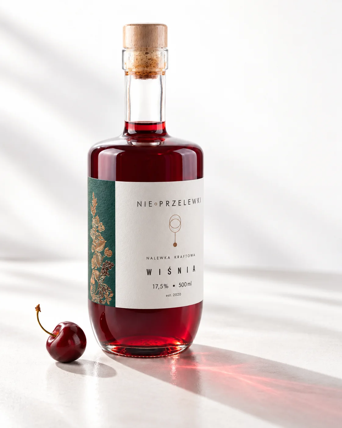 A 500 ml bottle of Sour Cherry from the side, the colour of the liquid against the light