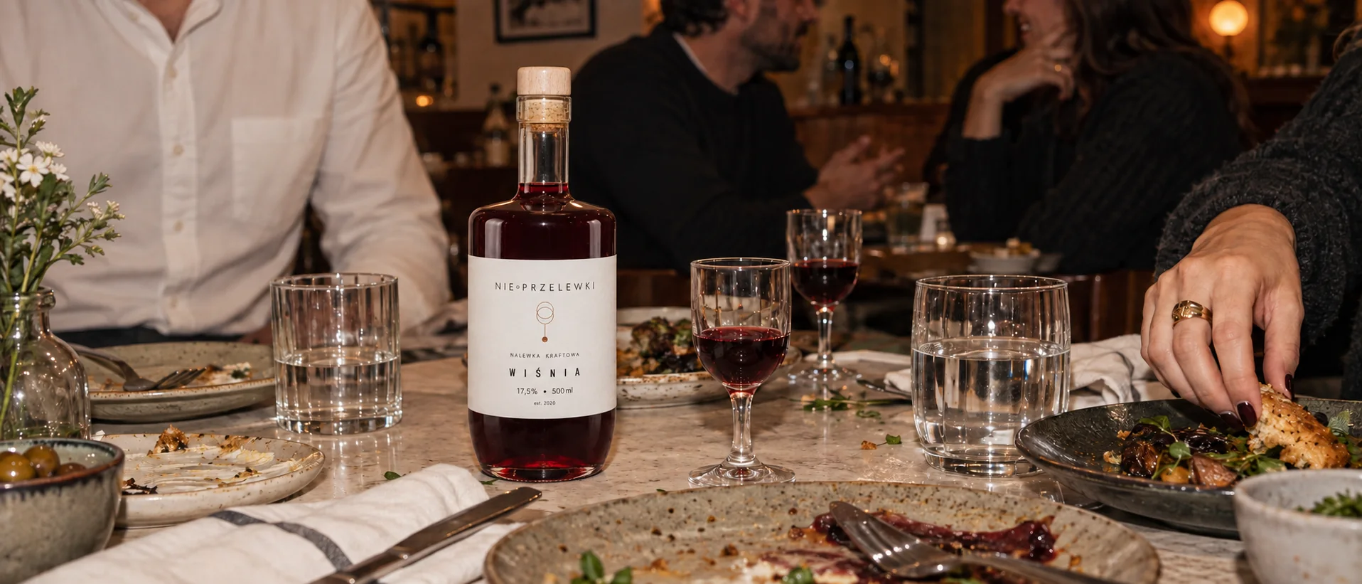 A bottle of Sour Cherry nalewka and glasses on the table at the end of dinner in a restaurant
