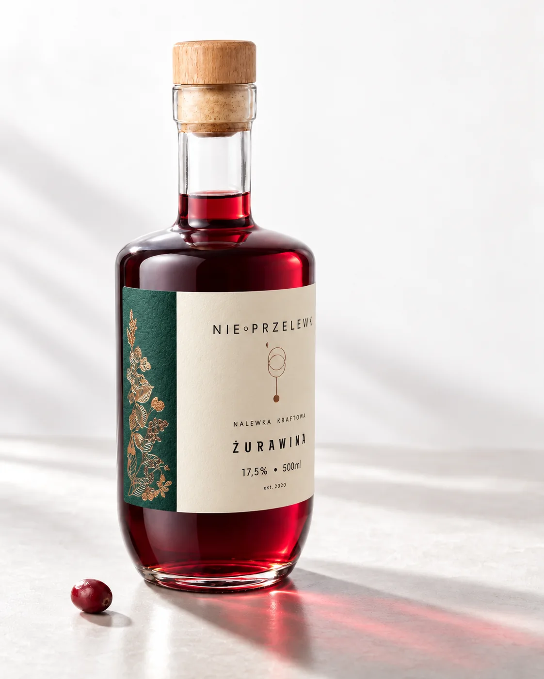 A 500 ml bottle of Cranberry from the side, the colour of the liquid against the light