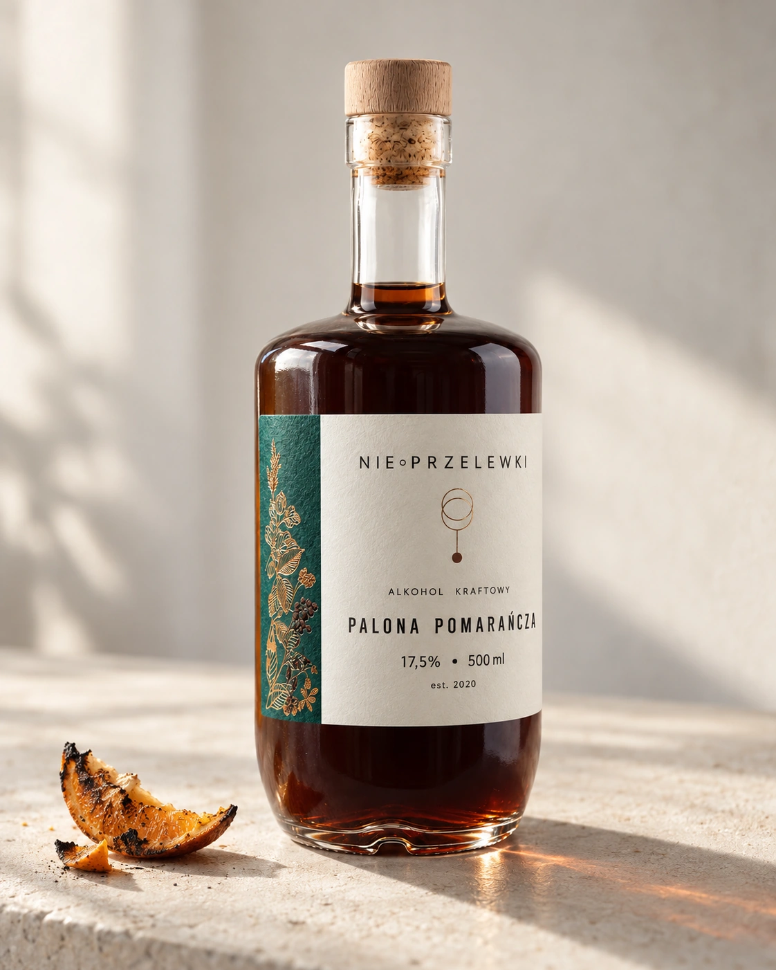 A 500 ml bottle of Burnt Orange from the side, the colour of the liquid against the light